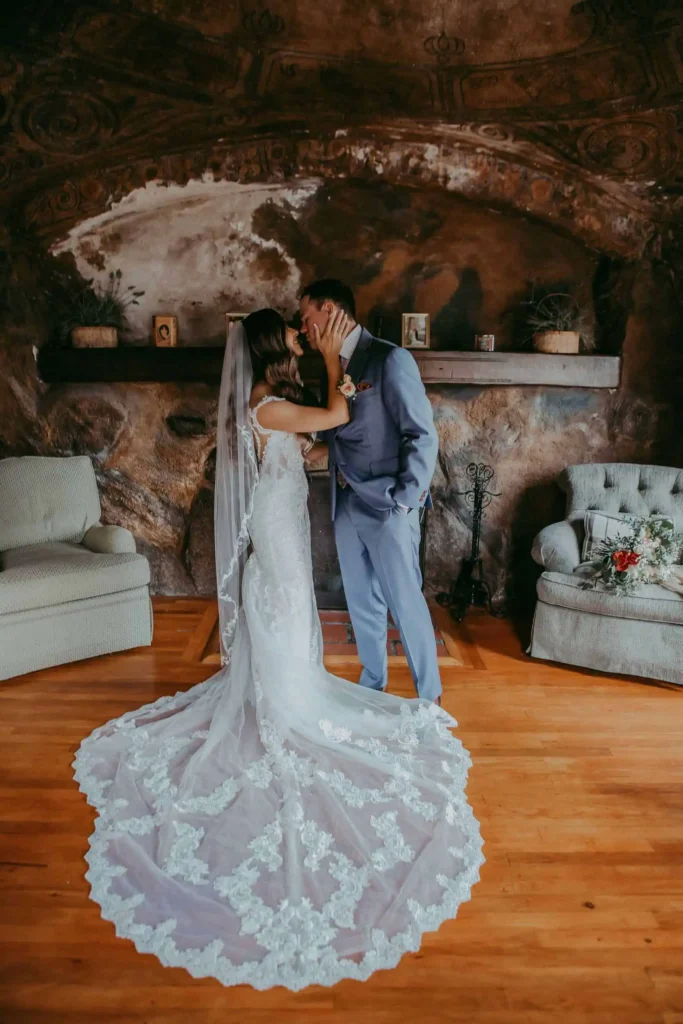 couple kisses in front of a fireplace